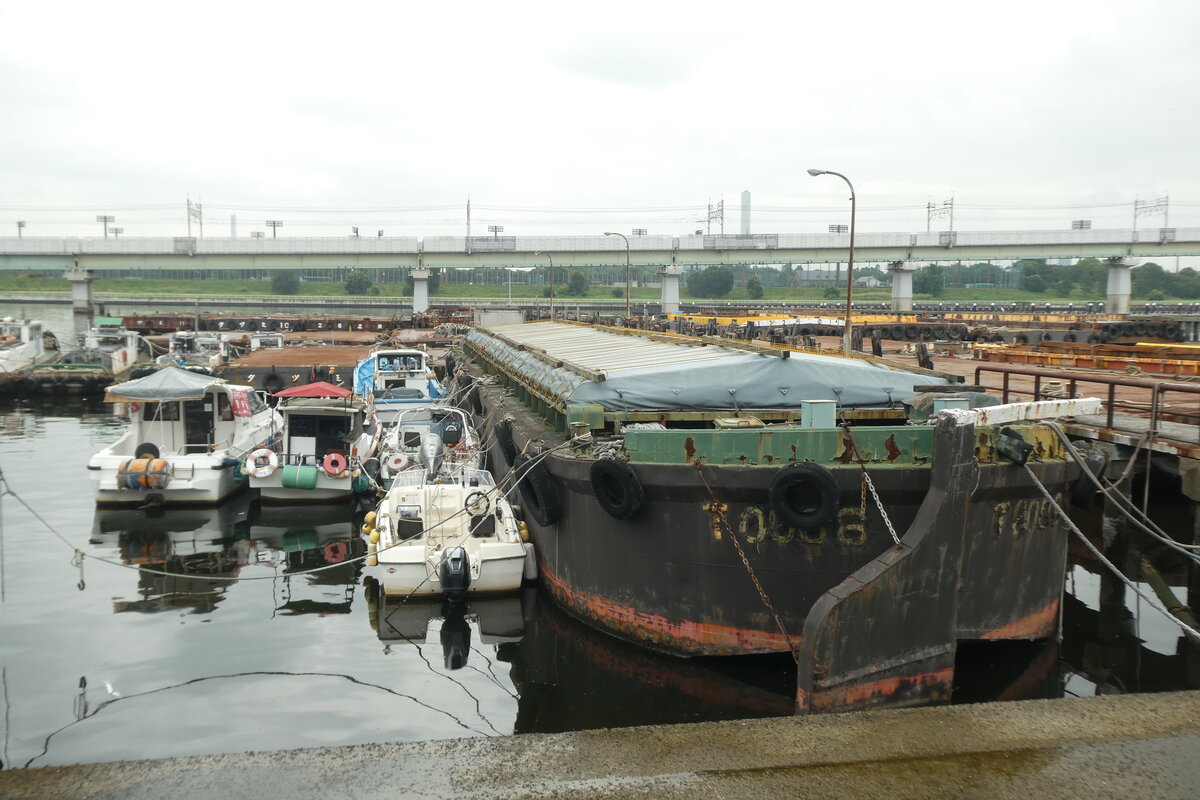 Auf Akebono-kanal (Tatsumi) sind mehrere Lastkähne und boote geparkt. In Tokio gibt es enge Kanäle aus der Edo-Zeit, die ein vorsichtiges Manövrieren erfordern. Daher verfügen von Schleppboote gezogene Lastkähne über Ruder. 16.Juli.2024