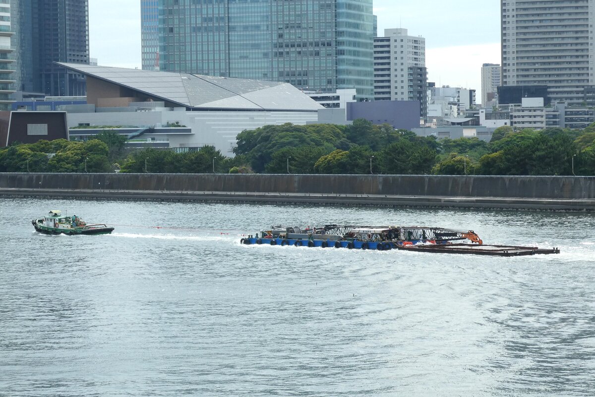 Japanische binnen-schleppboot  Eishin Maru Nr.11  (第十一栄進丸) wird den mit Baumaschine beladenen Lastkahn schleppen und den Sumida-Fluss hinunter nach Süden fahren. 
 24.Juni.2024.