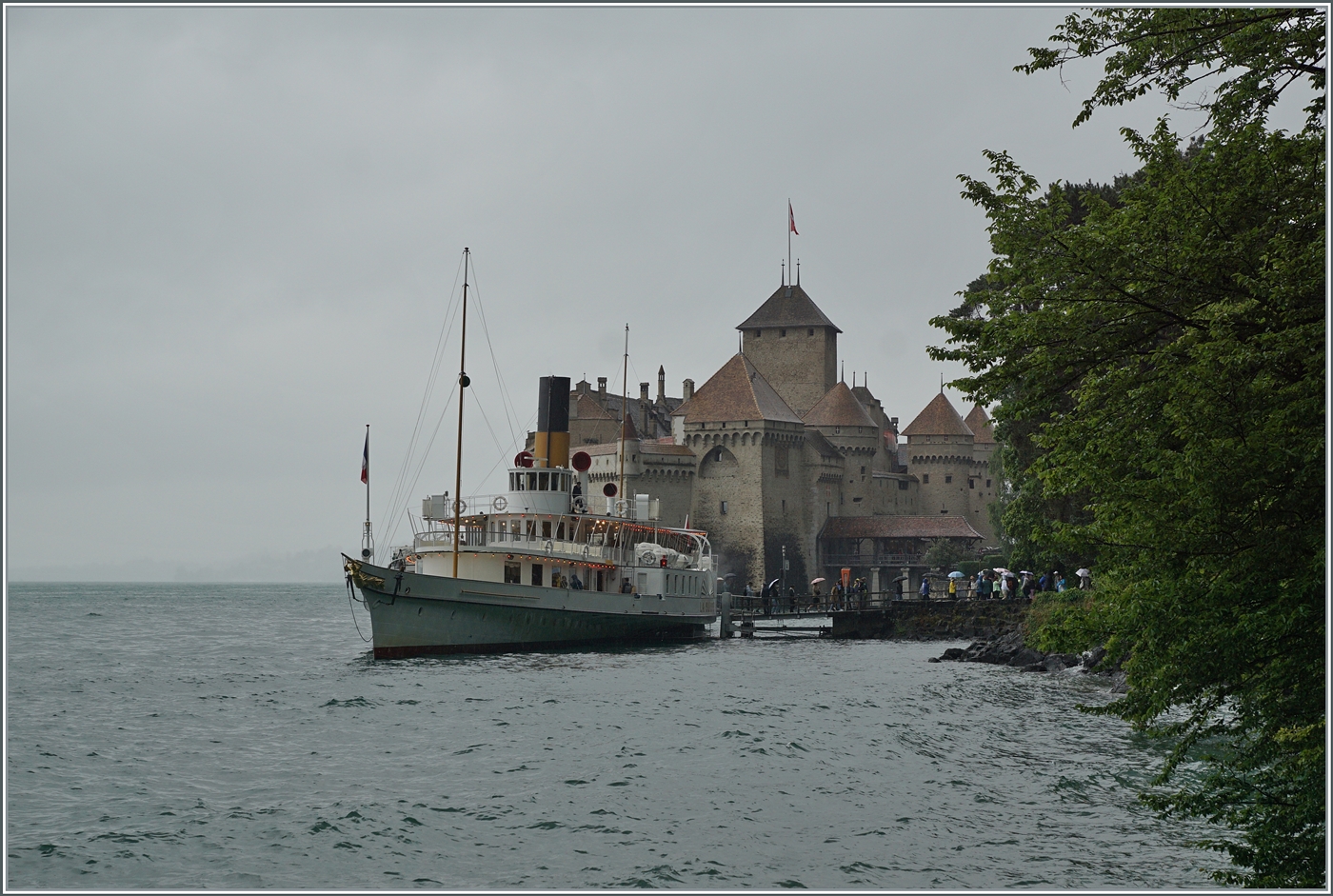 Eine Schiffsfahrt hat auch bei  schlechtem Wetter  seine Reize: der CGN Radschaufeldampfer LA SUISSE bei der Anlegestelle Château de Chillon nur die Lichter des Schiffs und die bunten Regenschirme der Reisenden bilden die wenigen Farbpunkte dieses Bildes.

22. Juni 2024