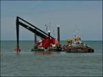 Hier positionniert der Schwimmkran einen grossen Felsbrocken im Wasser in der Nhe der Hafeneinfahrt von Oostende.  11.08.2010