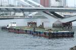 Der Lastkahn und das Schubboot  Takuyô Maru Nr.23  schließen den Frachtumschlag ab und verlassen das Ufer. 26.Juni.2024.