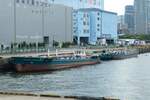 Das Japanische Binnen-Tankschiff  Kôshin Maru (興心丸) und  Kôun Maru (興運丸) liegt am Tsukishima Pier vor Anker.