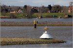 Der weie Kegel mit dem Leuchtfeuer markiert die Mndung der Hunte in die Weser (am unteren Bildrand) bei Elsfleth. Hinter dem Steinwall in der Bildmitte befindet sich eine Jachthafen. 23.03.2016