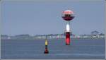 Das 22 m hohe Unterfeuer Hofe steht im Wasser der Auenweser. Im Hintergrund ist der Kutterhafen Wremertief mit seinem Leuchtturm  Kleiner Preue  zu erkennen. Im Vordergrund markiert eine schwarz-gelbe Tonne eine Untiefe. 05.07.2008