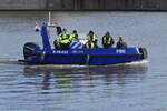 Ein Polizei Patrouillenboot fährt durch das Hafengebiet von Maastricht.