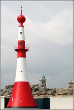 Das rot-weie Unterfeuer Bremerhaven ist seit 1893 in Betrieb und hat den Spitznamen Minarett. Das im Hintergrund ber den Zoo am Meer hinausragende Oberfeuer Bremerhaven, der sogenannte Loschenturm, ist bereits seit 1855 in Betrieb. Aufnahmedatum: 09.07.2005