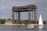 Ein Segelboot und eine kleine Personen- und Fahrradfhre vor der im 2. Weltkrieg von den Deutschen selbst zerstrten Eisenbahnhubbrcke ber den Peenestrom bei Karnin. Aufnahmedatum: 27.08.2005