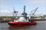 Die 1999 gebaute RT PIONEER (IMO 9190614) fhrt am 23.03.2016 durch den Kaiserhafen I in Bremerhaven. Auf diesem Bild wird der Schlepper eingerahmt von dem 1899 errichteten und inzwischen unter Denkmalschutz stehenden Druckwasserdrehkran (rechts) und der 1976 in Leichtbauweise errichteten Containerbrcke (links), die im Volksmund Giraffe genannt wird.