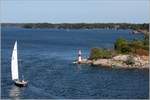 Das Leuchtfeuer Lunsen (Int. Nr. C6426) im Stockholmer Schärengarten wird von einer Segelyacht passiert. 22.07.2018